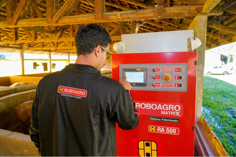 Técnico da ROBOAGRO realiza ajustes no robô em uma granja credenciada.